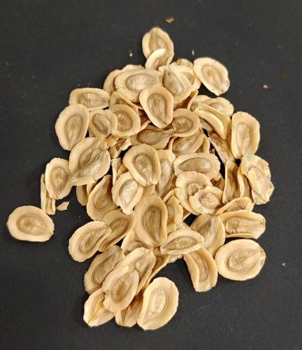 Pile of dried, peeled almonds on a dark background